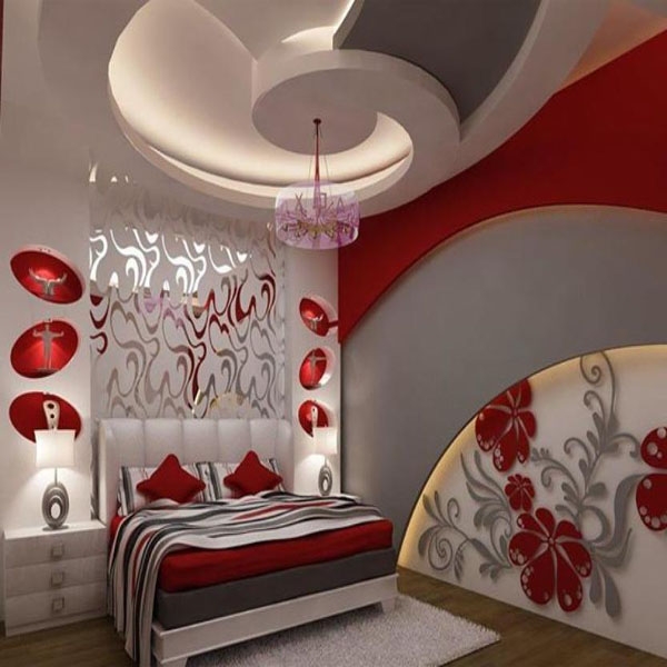 на стіні спальні малюнок з квітів, стелі а вигляді заокругленої стелі, багато червоних деталей у спальні