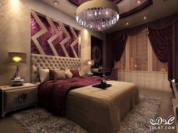 спальня з великою люстрою над ліжком з фіолетовими вкладеннями